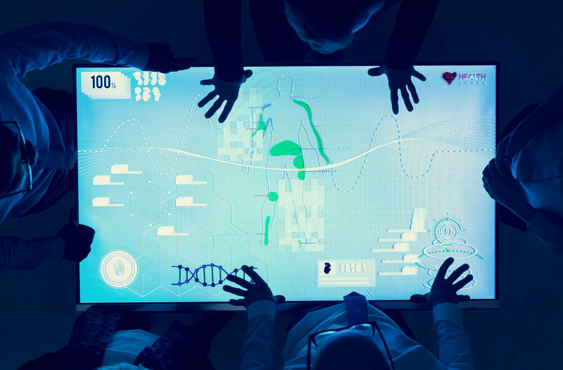 Gruppe arbeitet gemeinsam an medizinischer Analyse auf kapazitivem Touchscreen