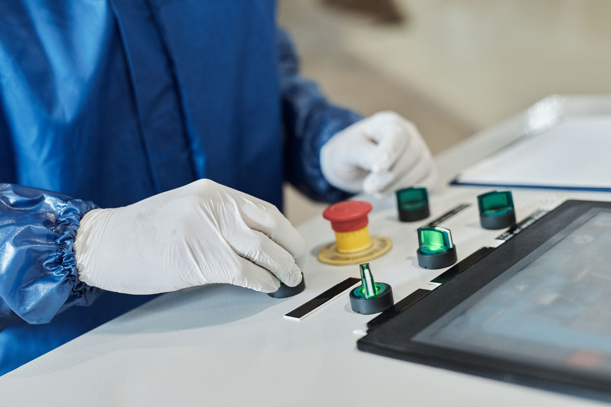 Bedienfeld mit resistivem Touchscreen und Tastern in Industrieumgebung, bedient mit Schutzhandschuhen