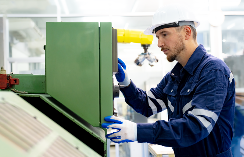 Ingenieur bedient resistives Touchpanel in einer Fabrikhalle