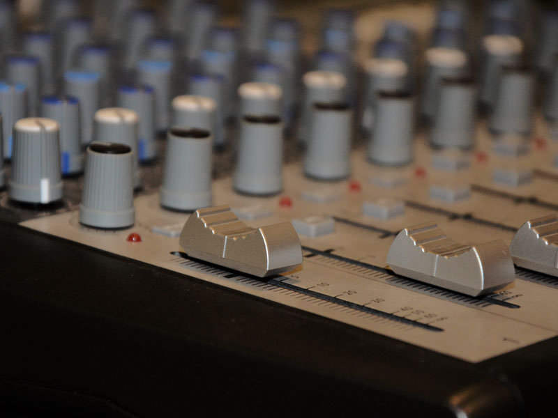 Schieberegler und Drehknöpfe auf einem Mischpult mit Designfolie