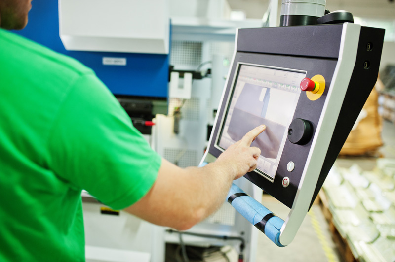 Maschinenbediener nutzt Touchscreen für Automation an Produktionsmaschine